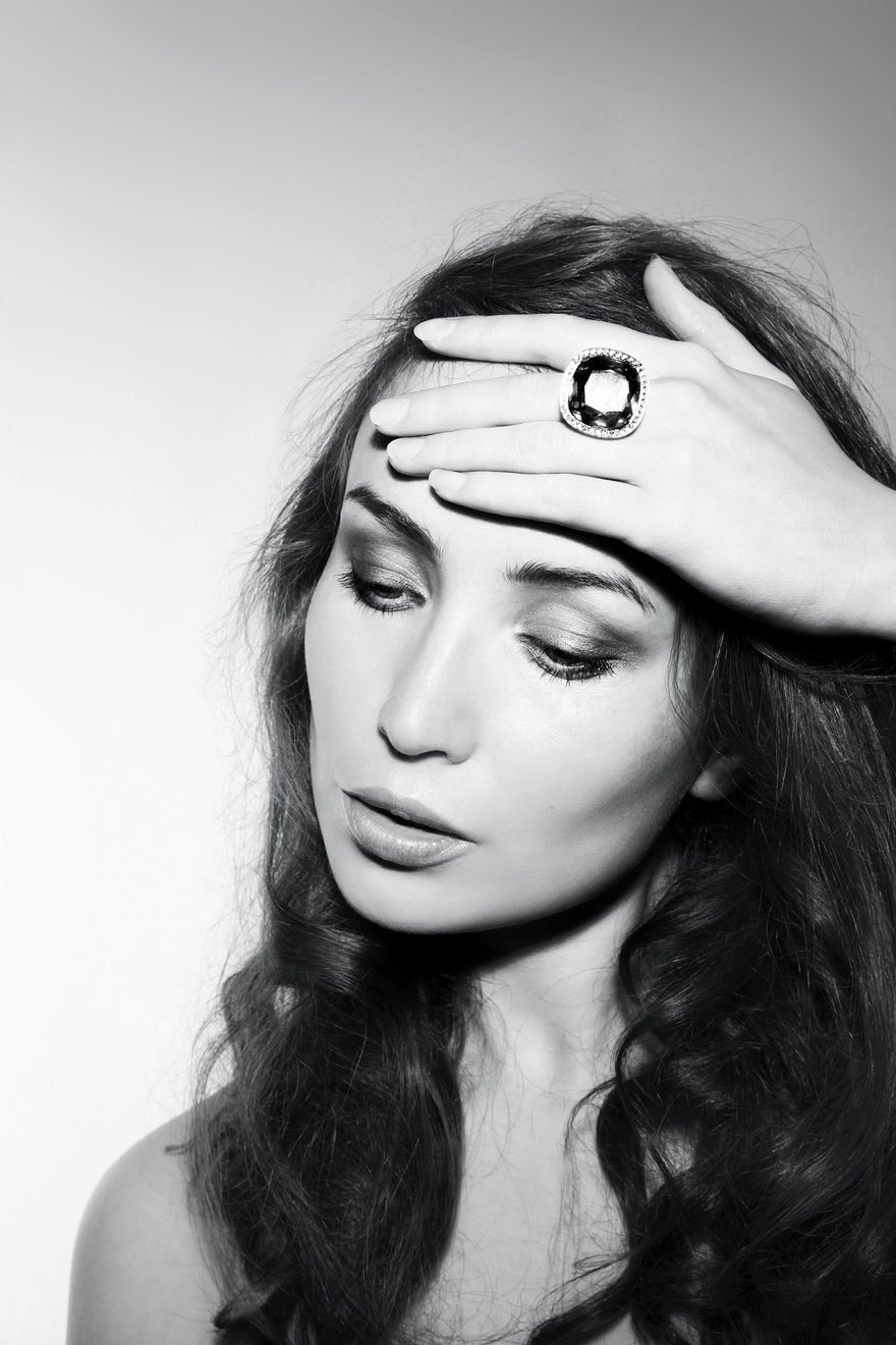 A black-and-white portrait of a woman wearing a ring with a large cushion-cut stone